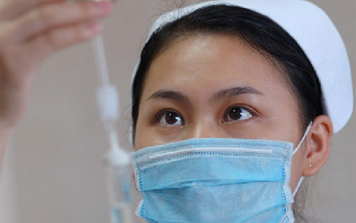 佩戴医用口罩的护士给患者输液